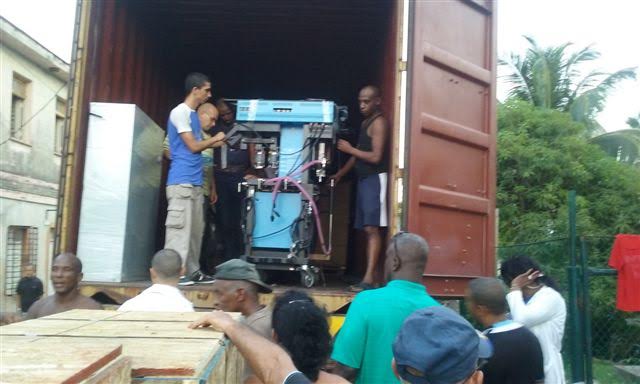 Cubans unload an anaesthesia machine from Canada